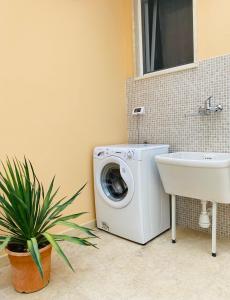 a bathroom with a washing machine and a sink at Civico35 in San Vito dei Normanni