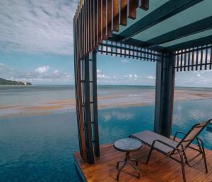a porch with two chairs and a table and the ocean at Imperium Residence Kuantan Cityview with Washing Machine in Kuantan