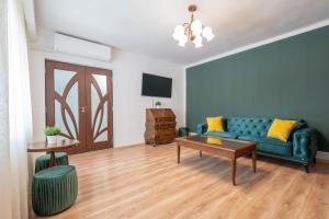 sala de estar con sofá azul y mesa en Salca Home en Oradea