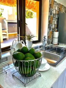 a bowl of limes on a kitchen counter next to a sink at iKhaya LamaDube Game Lodge in Klipdrift