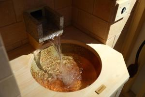 a bowl with water pouring out of a bird feeder at Onyado Nono Matsumoto Natural Hot Spring in Matsumoto