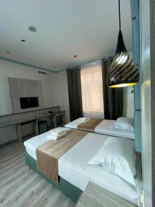 a bedroom with two beds and a pendant light at Atrium Hotel in Bukhara