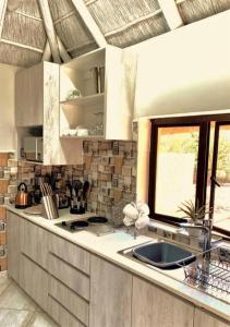 a kitchen with a sink and a window at iKhaya LamaDube Game Lodge in Klipdrift