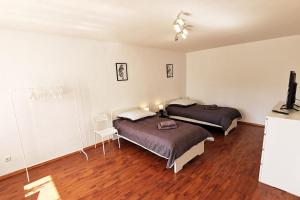 2 łóżka w pokoju z drewnianą podłogą w obiekcie Nice apartment in Heusenstamm near Frankfurt w mieście Heusenstamm