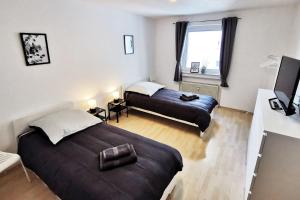 sypialnia z 2 łóżkami i telewizorem w obiekcie Nice apartment in Heusenstamm near Frankfurt w mieście Heusenstamm