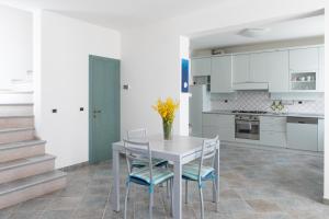 a white kitchen with a table and chairs at FONTE D'OLIO CONERO RELAIS in Sirolo