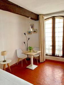 a room with a table and a chair and a bed at Le 1835, Studio Ambre-Jaune in Moustiers-Sainte-Marie
