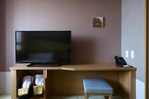 a desk with a television and a phone on it at Onyado Nono Matsumoto Natural Hot Spring in Matsumoto