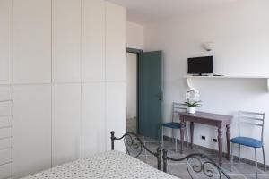 a bedroom with a bed and a desk and a tv at FONTE D'OLIO CONERO RELAIS in Sirolo