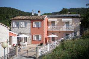 a house with a balcony and a patio with umbrellas at FONTE D'OLIO CONERO RELAIS in Sirolo