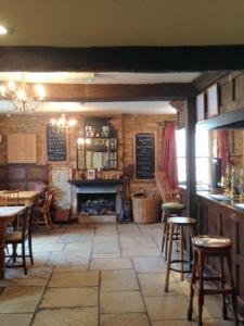 a restaurant with a fireplace and tables and chairs at The Royal Oak Burford in Burford
