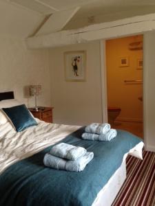 a bedroom with a bed with three towels on it at The Royal Oak Burford in Burford