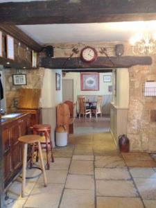 a kitchen and dining room with a clock on the wall at The Royal Oak Burford in Burford