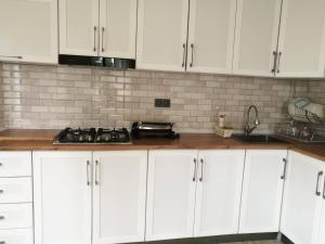 una cucina bianca con armadi bianchi e piano cottura di Mate's GUEST HOUSE a Kobuleti