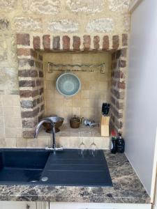 eine Küchentheke mit einer Spüle und einer Steinmauer in der Unterkunft 71 Main Street in Bishopthorpe