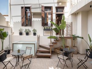 a balcony with tables and chairs and plants at Old Town Suites in Chania Town