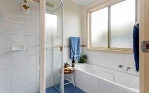 a bathroom with a tub and a window at Carrawaves 73 LaRonde in Carrickalinga +12 photos