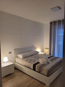 a white bedroom with a bed and a window at B&B il Bacio in Perugia