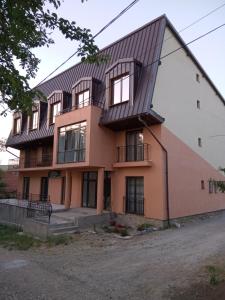 an orange building with a metal roof at Pensiunea Valea Beiului in Socolari