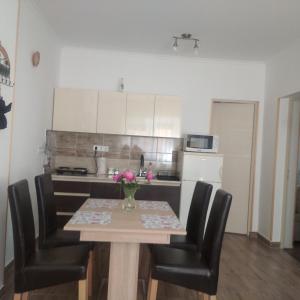 eine Küche mit einem Tisch und einer Blumenvase darauf in der Unterkunft Kaptárkő Apartmanház in Demjén