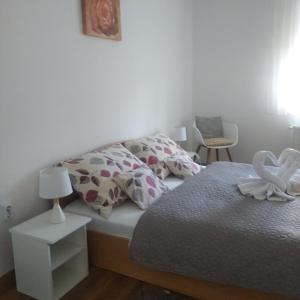 a bedroom with a bed with a swan decoration on it at Kaptárkő Apartmanház in Demjén