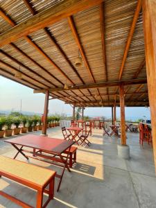 un pabellón de madera con mesas de picnic y bancos en Casa Losodeli & Coworking- Adults Only, en Puerto Escondido