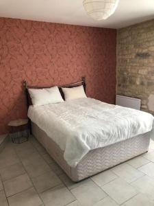 a bedroom with a large bed with a red wall at Gîte de l'hortensia-Charmante maison de campagne au calme in Gourville