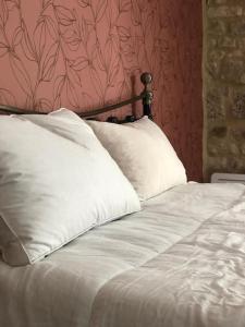 a bed with white sheets and pillows in a bedroom at Gîte de l'hortensia-Charmante maison de campagne au calme in Gourville