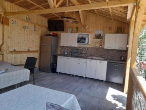a kitchen with white cabinets and a refrigerator at Casa Remus in Sulina