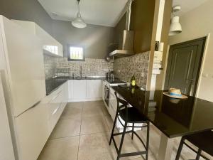 a kitchen with white cabinets and a black counter top at Magnifique gîte au coeur d'une truffière in Le Garn