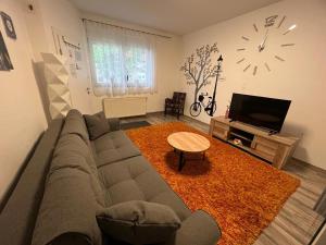Una sala de estar con un sofá, una mesa y un televisor. en Apartman Dunav - PARKING - Self check in, en Osijek