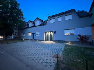 een groot wit huis met een oprit 's nachts bij Apartment Dunav in Osijek