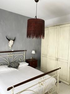 a bedroom with a bed and a chandelier at Karpathian Minimalism in Arkasa