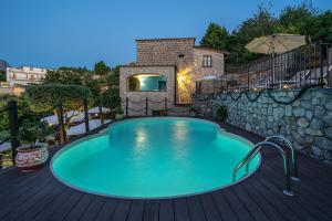 a swimming pool on a deck with a stone wall at Villa Denise in Vico Equense