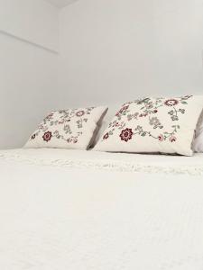 a white bed with two pillows on top of it at Karpathian Minimalism in Arkasa