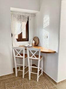 a small kitchen with a table and two chairs at Karpathian Minimalism in Arkasa