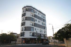 a tall white building on the corner of a street at LaLa Apartment and Hotel in Danang