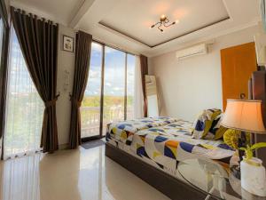 a bedroom with a bed and a large window at Villa Kamar Tamu Warungboto in Yogyakarta
