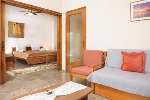 イエリソスにあるDili Apartmentsのベッド、ソファ、椅子が備わる客室です。