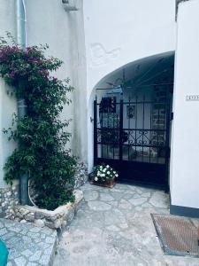 an entrance to a building with a gate with flowers at Apartments Getruda in Krk