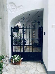 een toegang tot een zwarte poort met een potplant bij Apartments Getruda in Krk