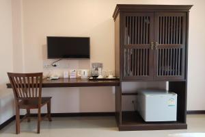 a room with a desk with a television and a chair at Pai Sukhothai Resort SHA Extra Plus in Sukhothai