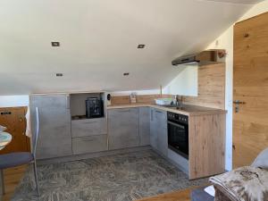 a kitchen with stainless steel appliances and wooden floors at Ferienwohnung Allgäuglück in Oberreute