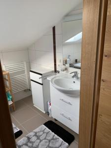 a white bathroom with a sink and a mirror at Ferienwohnung Allgäuglück in Oberreute