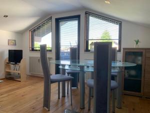 a dining room with a glass table and chairs at Ferienwohnung Allgäuglück in Oberreute