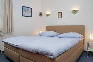 een bed in een slaapkamer met 2 kussens erop bij Fischerhus _ Wohnung 5 in Cuxhaven