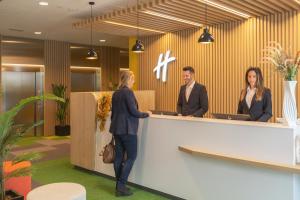 a group of people standing at a reception desk at Holiday Inn Barcelona - Sant Cugat, an IHG Hotel in Sant Cugat del Vallès