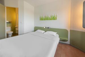トゥールーズにあるB&B HOTEL Toulouse Cité de l'Espace Gonordのベッドルーム(大型ベッド1台付)、バスルームが備わります。