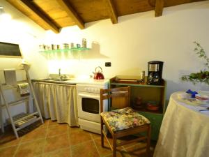 a kitchen with a stove and a sink and a table at Scenic apartment in Vezzi Portio with private garden in Vezzi Portio