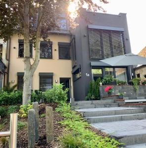 Una casa con escaleras y un árbol delante. en Zur Rotbuche, en Zeltingen-Rachtig